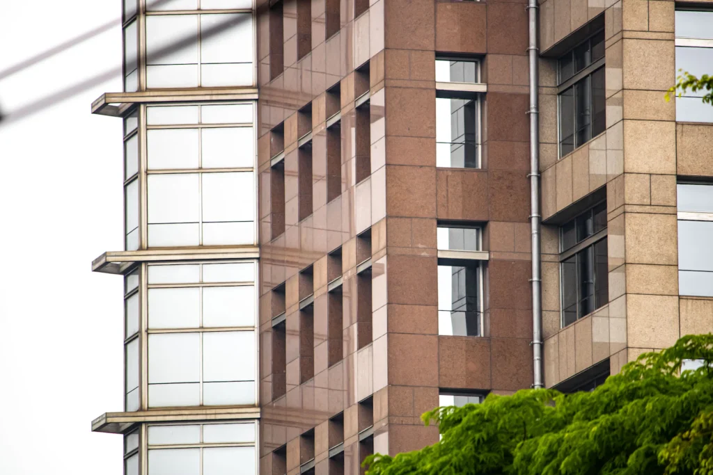 Fachada de prédio residencial com varandas e árvores em frente